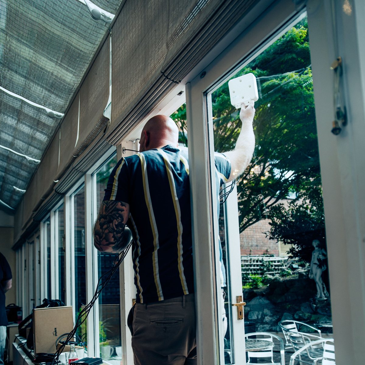 A delegate holding a panel antenna up at the conservatory door to find the strongest signal